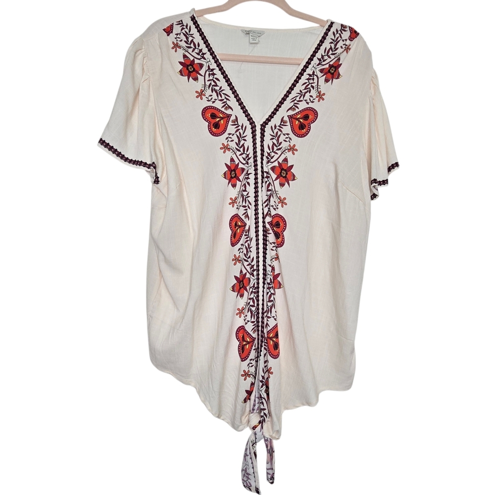 Cream or off-white short-sleeved blouse featuring vibrant red and maroon floral
